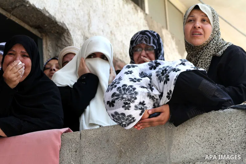 Palestinian women watch the funeral of two-year-old Hadeel al Hadad, during her funeral in Gaza City, Wednesday, June 20, 2012. Gaza health official Adham Abu Salmia said an explosion in a house killed al-Hadad and injur...