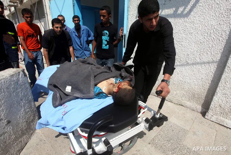 Palestinian men carry the body of Moamen al-Adam, 14, to the morgue of Al-Shifa hospital in Gaza City on June 20, 2012 after he was killed and his father Zohde Al-Dam in an Israeli air strike raising to eight the number...