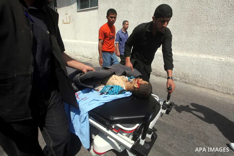 Palestinian men carry the body of Moamen al-Adam, 14, to the morgue of Al-Shifa hospital in Gaza City on June 20, 2012 after he was killed and his father Zohde Al-Dam in an Israeli air strike raising to eight the number...