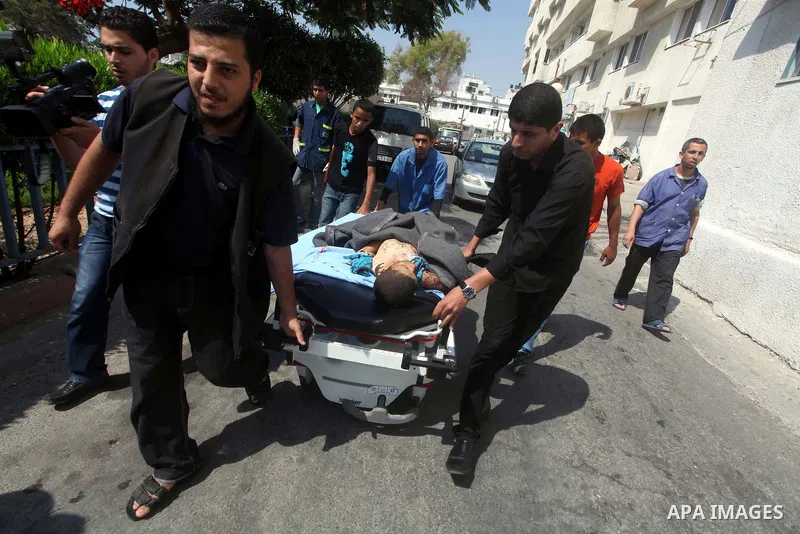 Palestinian men carry the body of Moamen al-Adam, 14, to the morgue of Al-Shifa hospital in Gaza City on June 20, 2012 after he was killed and his father Zohde Al-Dam in an Israeli air strike raising to eight the number...
