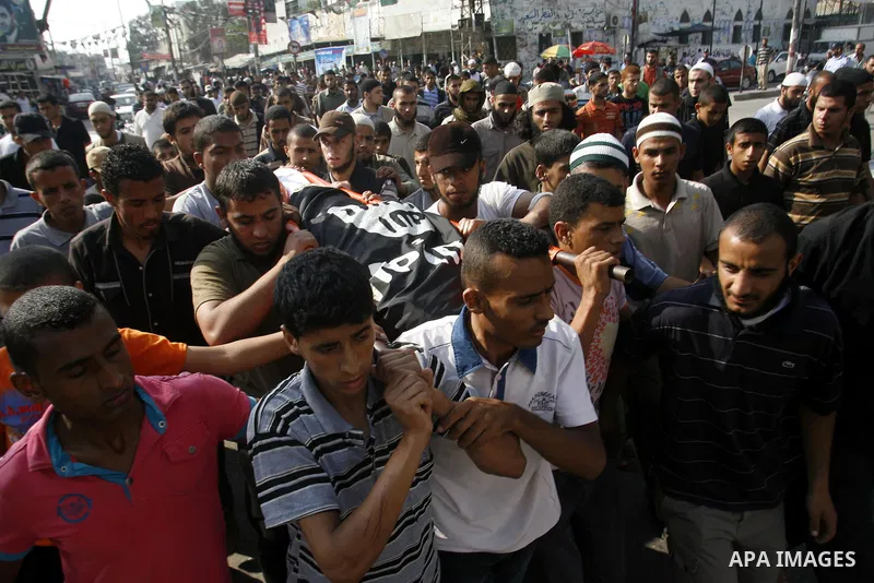 Relatives carry the body of Palestinian militant Galib Rmelat during his funeral in Rafah in the southern Gaza Strip June 20, 2012. Israeli air strikes killed a Palestinian militant and a 14-year-old boy as fighting acro...