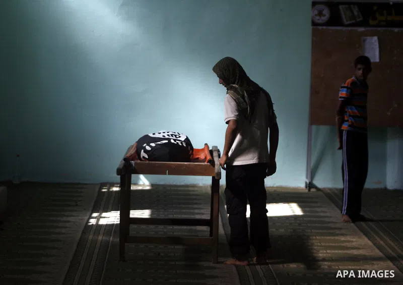 Relatives and friends mourn over the body of 21-year-old Ghaleb Rmilat during his funeral in Rafah, in the Gaza Strip on June 20, 2012, Israeli air strikes killed a Palestinian militant and a 14-year-old boy on Wednesday...