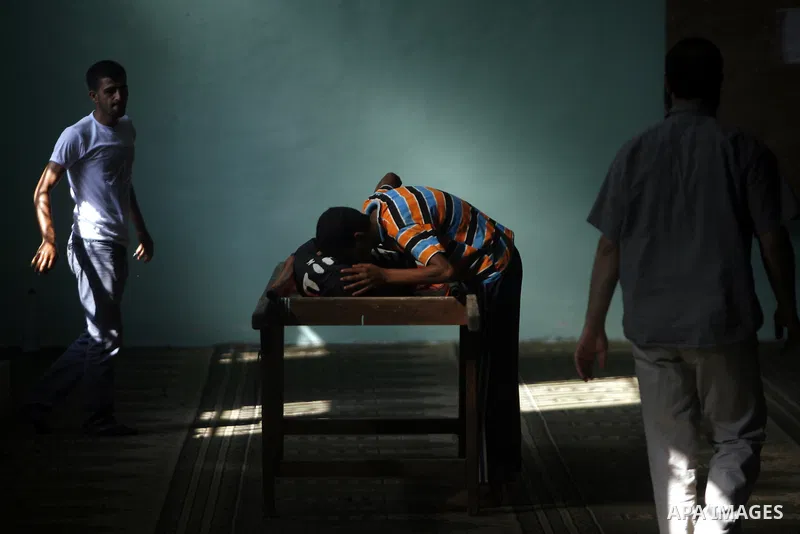 Relatives and friends mourn over the body of 21-year-old Ghaleb Rmilat during his funeral in Rafah, in the Gaza Strip on June 20, 2012, Israeli air strikes killed a Palestinian militant and a 14-year-old boy on Wednesday...