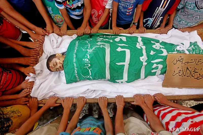 friends of 14-year old Palestinian Moamen al-Adam, who was killed in an Israeli air strike the day before, bids farewell to him during his funeral procession in Gaza city on June 21, 2012. The latest attacks follow three...