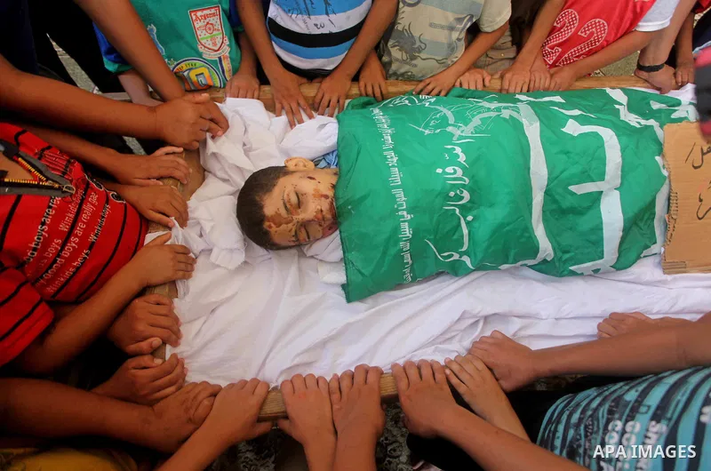 friends of 14-year old Palestinian Moamen al-Adam, who was killed in an Israeli air strike the day before, bids farewell to him during his funeral procession in Gaza city on June 21, 2012. The latest attacks follow three...
