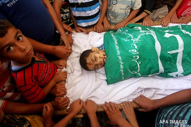 friends of 14-year old Palestinian Moamen al-Adam, who was killed in an Israeli air strike the day before, bids farewell to him during his funeral procession in Gaza city on June 21, 2012. The latest attacks follow three...