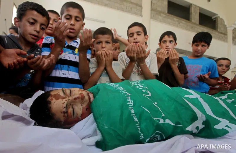 friends of 14-year old Palestinian Moamen al-Adam, who was killed in an Israeli air strike the day before, bids farewell to him during his funeral procession in Gaza city on June 21, 2012. The latest attacks follow three...
