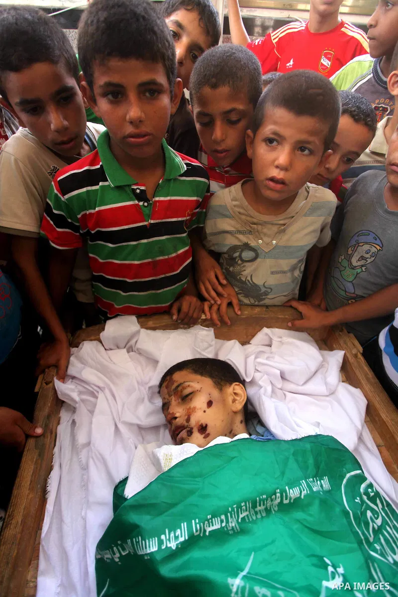 friends of 14-year old Palestinian Moamen al-Adam, who was killed in an Israeli air strike the day before, bids farewell to him during his funeral procession in Gaza city on June 21, 2012. The latest attacks follow three...
