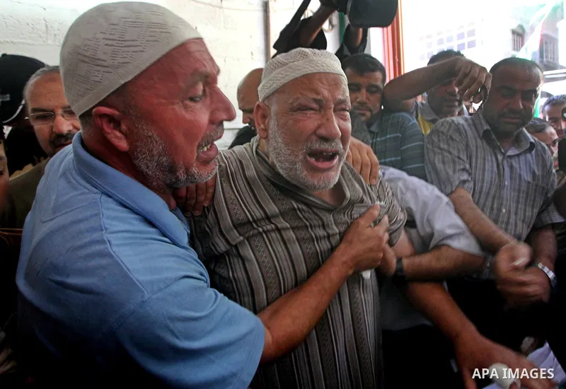 Palestinian Mohammed al-Dam grieves during the funeral of his son Mamon al-Dam, 14, in Gaza City, Thursday, June 21, 2012. Al Dam was killed on Wednesday during an Israeli air strike while he was playing at his family fa...