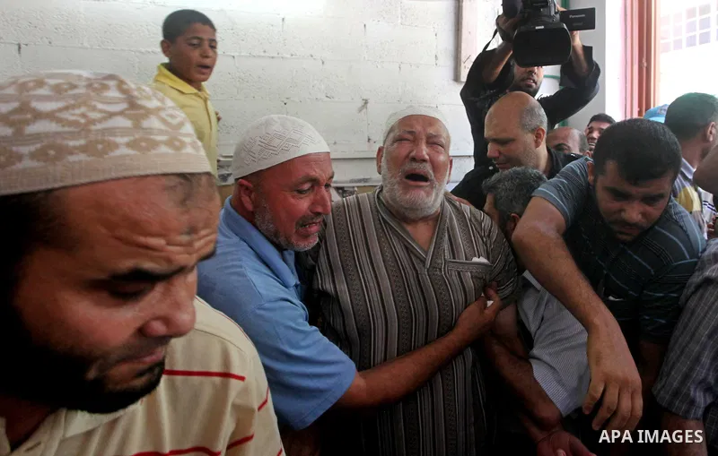 Palestinian Mohammed al-Dam grieves during the funeral of his son Mamon al-Dam, 14, in Gaza City, Thursday, June 21, 2012. Al Dam was killed on Wednesday during an Israeli air strike while he was playing at his family fa...