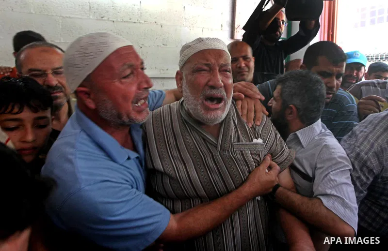 Palestinian Mohammed al-Dam grieves during the funeral of his son Mamon al-Dam, 14, in Gaza City, Thursday, June 21, 2012. Al Dam was killed on Wednesday during an Israeli air strike while he was playing at his family fa...