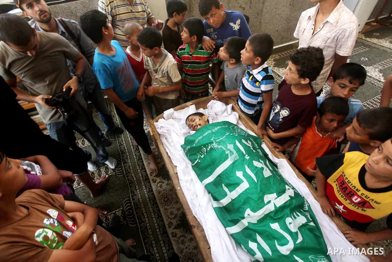 friends of 14-year old Palestinian Moamen al-Adam, who was killed in an Israeli air strike the day before, bids farewell to him during his funeral procession in Gaza city on June 21, 2012. The latest attacks follow three...