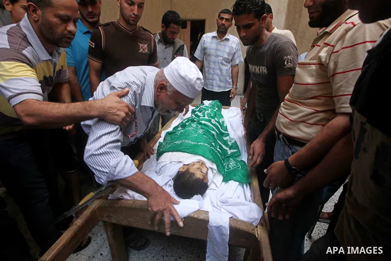 Palestinian Mohammed al-Dam grieves during the funeral of his son Mamon al-Dam, 14, in Gaza City, Thursday, June 21, 2012. Al Dam was killed on Wednesday during an Israeli air strike while he was playing at his family fa...