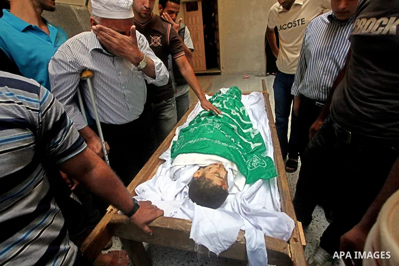 Relatives of 14-year old Palestinian Moamen al-Adam, who was killed in an Israeli air strike the day before, bids farewell to him during his funeral procession in Gaza city on June 21, 2012. The latest attacks follow thr...