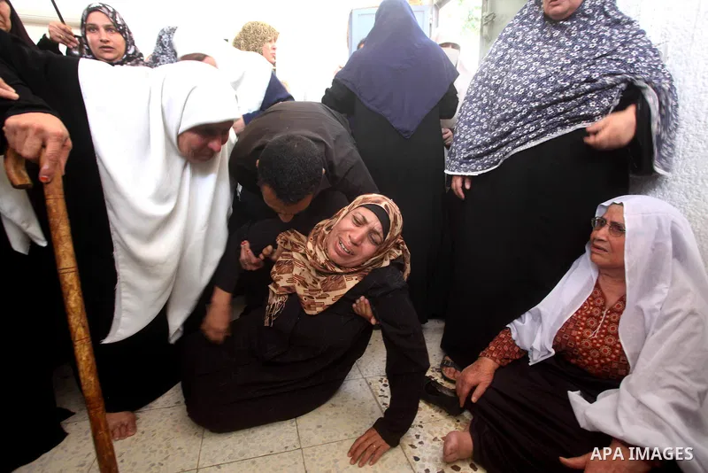 A Palestinian relative of a militant of al-Qassam brigades Thair Al-Baik, 30, collapses as she mourns during his funeral in Jabalia refugee camp in the northern Gaza Strip on June 21, 2012. Al-Baik one of two fighters fr...