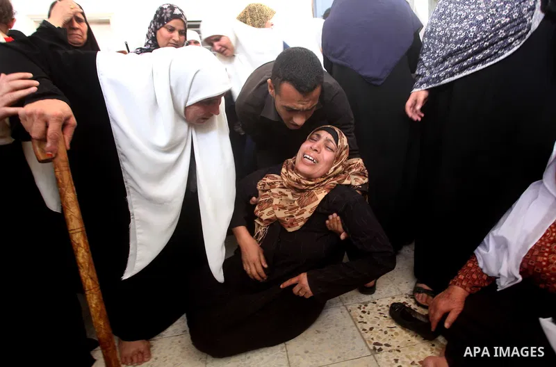 A Palestinian relative of a militant of al-Qassam brigades Thair Al-Baik, 30, collapses as she mourns during his funeral in Jabalia refugee camp in the northern Gaza Strip on June 21, 2012. Al-Baik one of two fighters fr...