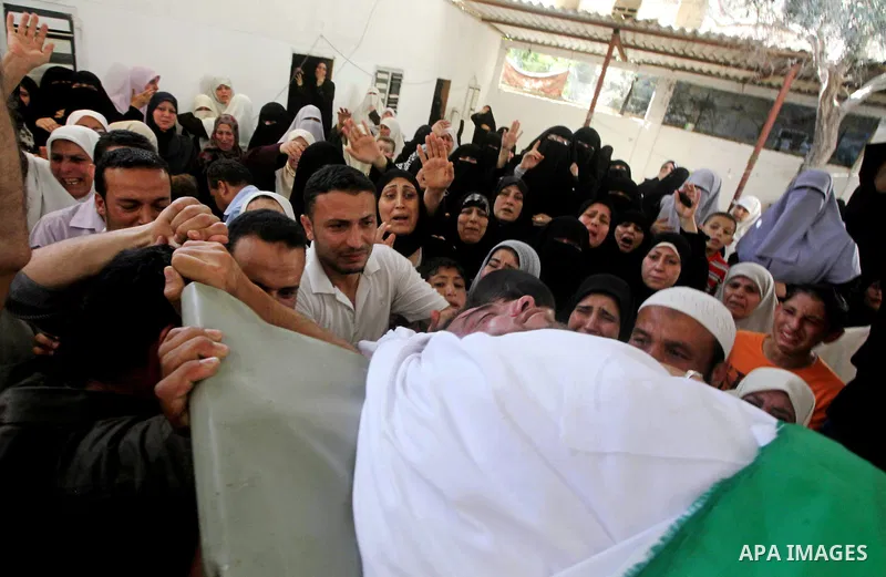Palestinian relatives of a militant of al-Qassam brigades Thair Al-Baik, 30, mourn during his funeral in Jabalia refugee camp in the northern Gaza Strip on June 21, 2012. Al-Baik one of two fighters from al-Qassam brigad...