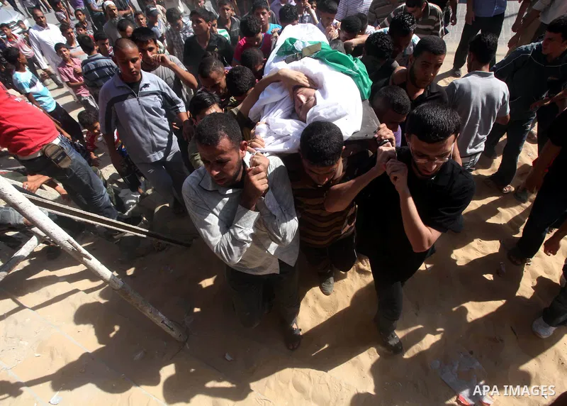 Palestinian mourners carry the body of a militant of al-Qassam brigades Thair Al-Baik, 30, during his funeral in Jabalia refugee camp in the northern Gaza Strip on June 21, 2012. Al-Baik one of two fighters from al-Qassa...
