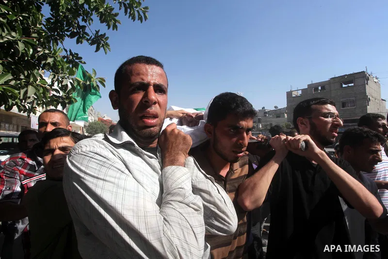 Palestinian mourners carry the body of a militant of al-Qassam brigades Thair Al-Baik, 30, during his funeral in Jabalia refugee camp in the northern Gaza Strip on June 21, 2012. Al-Baik one of two fighters from al-Qassa...