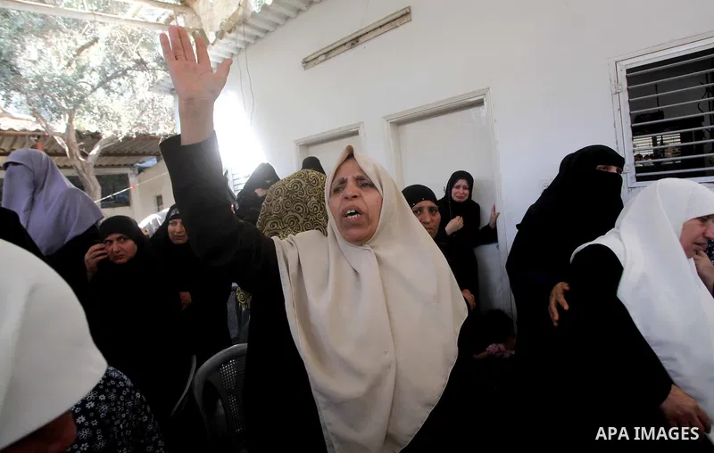 Palestinian relatives of a militant of al-Qassam brigades Thair Al-Baik, 30, mourn during his funeral in Jabalia refugee camp in the northern Gaza Strip on June 21, 2012. Al-Baik one of two fighters from al-Qassam brigad...