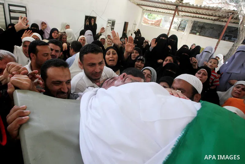 Palestinian relatives of a militant of al-Qassam brigades Thair Al-Baik, 30, mourn during his funeral in Jabalia refugee camp in the northern Gaza Strip on June 21, 2012. Al-Baik one of two fighters from al-Qassam brigad...