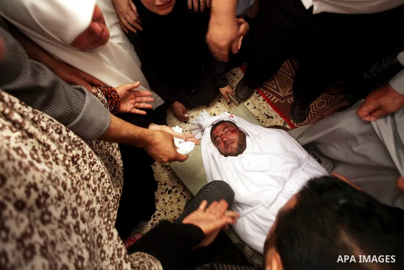Palestinian relatives of a militant of al-Qassam brigades Thair Al-Baik, 30, mourn during his funeral in Jabalia refugee camp in the northern Gaza Strip on June 21, 2012. Al-Baik one of two fighters from al-Qassam brigad...