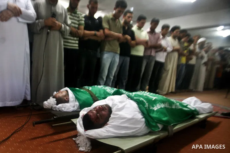 Palestinian mourners pray over the body f Hamas militant Thair al-Bik, and Mohammed al-Khaldi, during their funeral in Jabaliya Refugee Camp, northern Gaza Strip, Thursday, June 21, 2012. Al-Bik and Al-Khaldi two Hamas m...