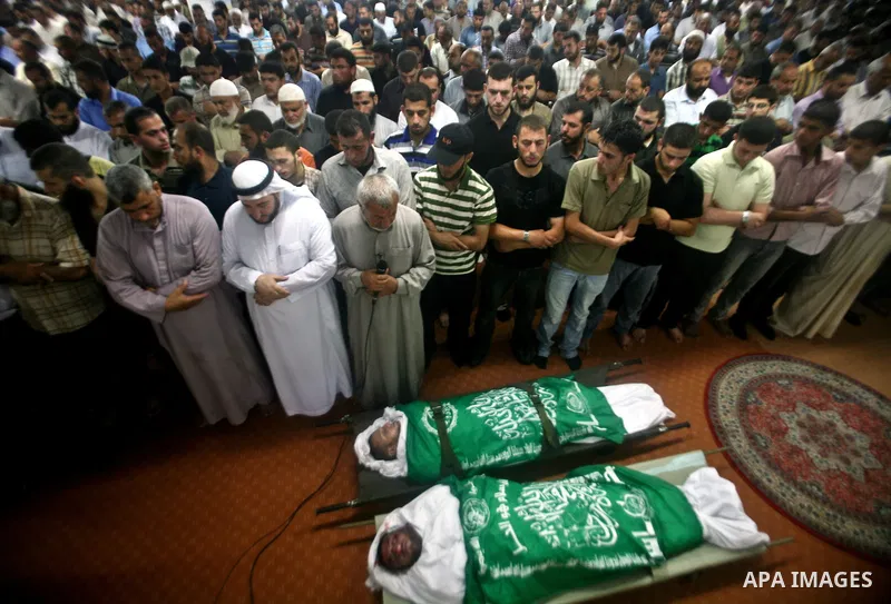 Palestinian mourners pray over the body f Hamas militant Thair al-Bik, and Mohammed al-Khaldi, during their funeral in Jabaliya Refugee Camp, northern Gaza Strip, Thursday, June 21, 2012. Al-Bik and Al-Khaldi two Hamas m...