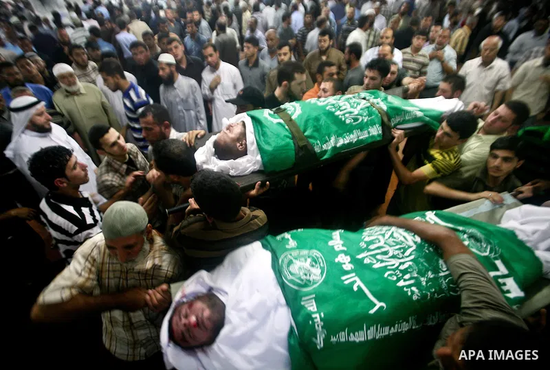 Palestinian mourners carry the body of Hamas militant Thair al-Bik, and Mohammed al-Khaldi , during their funeral in Jabaliya Refugee Camp, northern Gaza Strip, Thursday, June 21, 2012. Al-Bik and Al-Khaldi two Hamas mil...