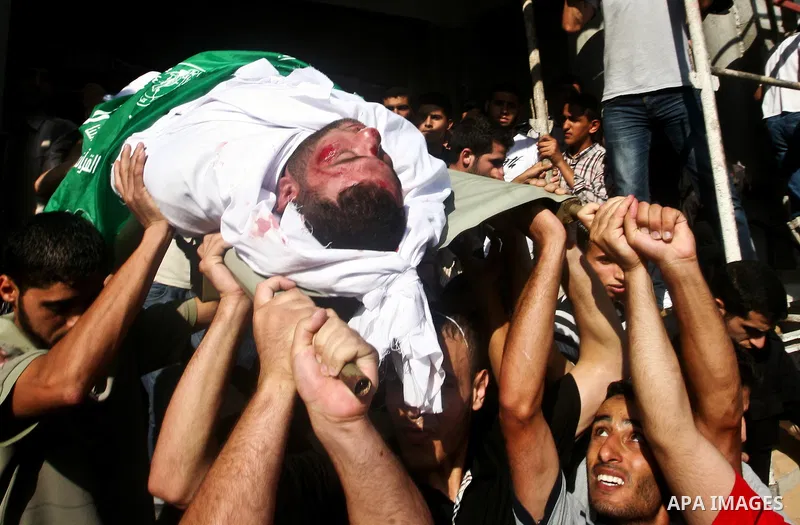 Palestinian mourners carry the body of Hamas militant Thair al-Bik, and Mohammed al-Khaldi , during their funeral in Jabaliya Refugee Camp, northern Gaza Strip, Thursday, June 21, 2012. Al-Bik and Al-Khaldi two Hamas mil...