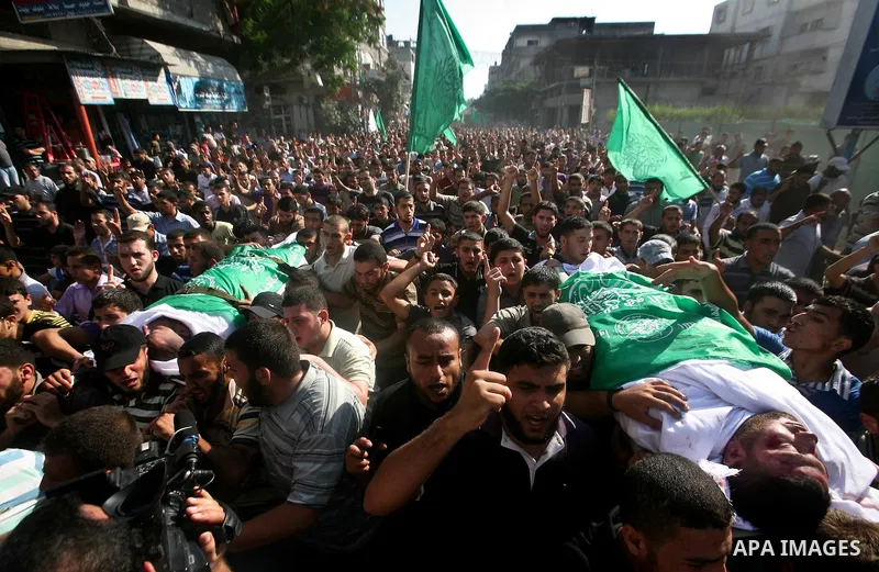 Palestinian mourners carry the body of Hamas militant Thair al-Bik, and Mohammed al-Khaldi , during their funeral in Jabaliya Refugee Camp, northern Gaza Strip, Thursday, June 21, 2012. Al-Bik and Al-Khaldi two Hamas mil...
