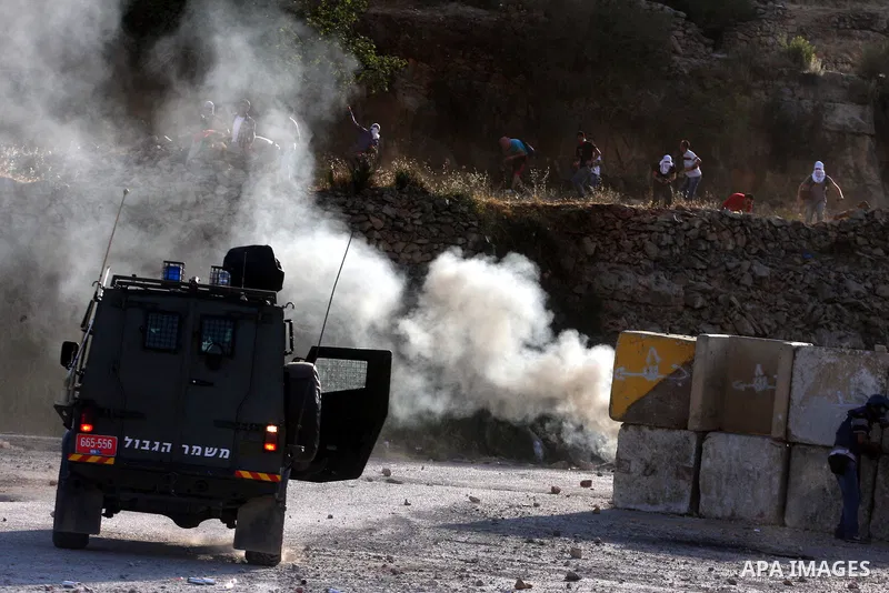 Palestinian protestors throw stones during clashes with Israeli police following a demonstration outside Ofer prison, near the West Bank city of Ramallah, in solidarity with Palestinian prisoners being held in Israeli ja...