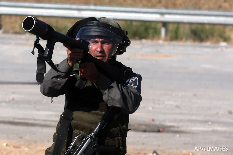 An Israeli soldier shoots tear gas at Palestinian protestors during clashes following a demonstration outside Ofer prison, near the West Bank city of Ramallah, in solidarity with Palestinian prisoners being held in Israe...