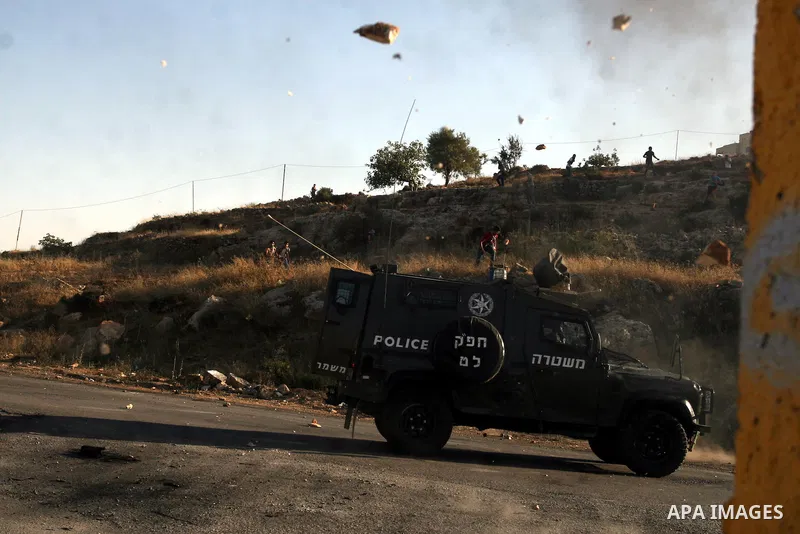 Palestinian protestors throw stones during clashes with Israeli police following a demonstration outside Ofer prison, near the West Bank city of Ramallah, in solidarity with Palestinian prisoners being held in Israeli ja...