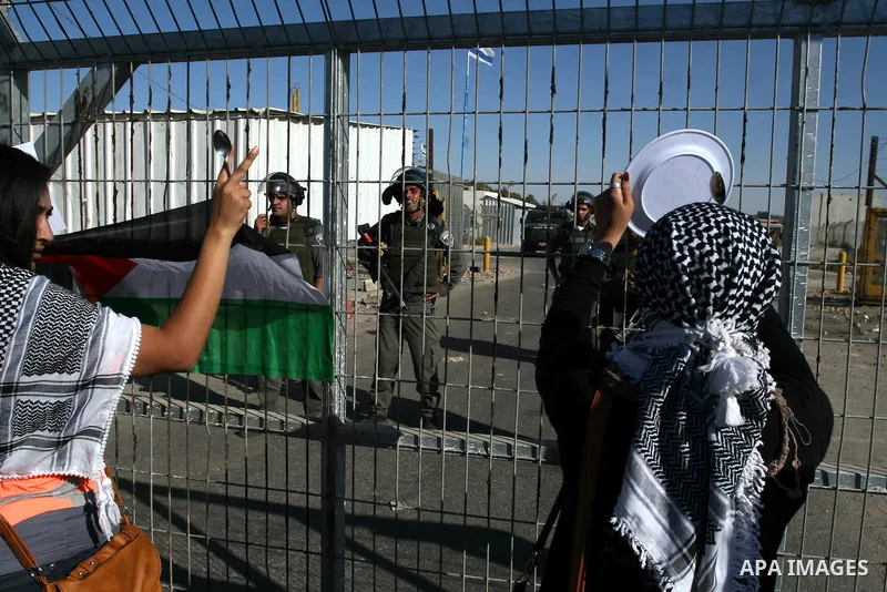 Palestinian female protestors shout anti-Israel slogans at soldiers manning the Bitwonia crossing during a demonstration outside Ofer prison, near the West Bank city of Ramallah, in solidarity with Palestinian prisoners...