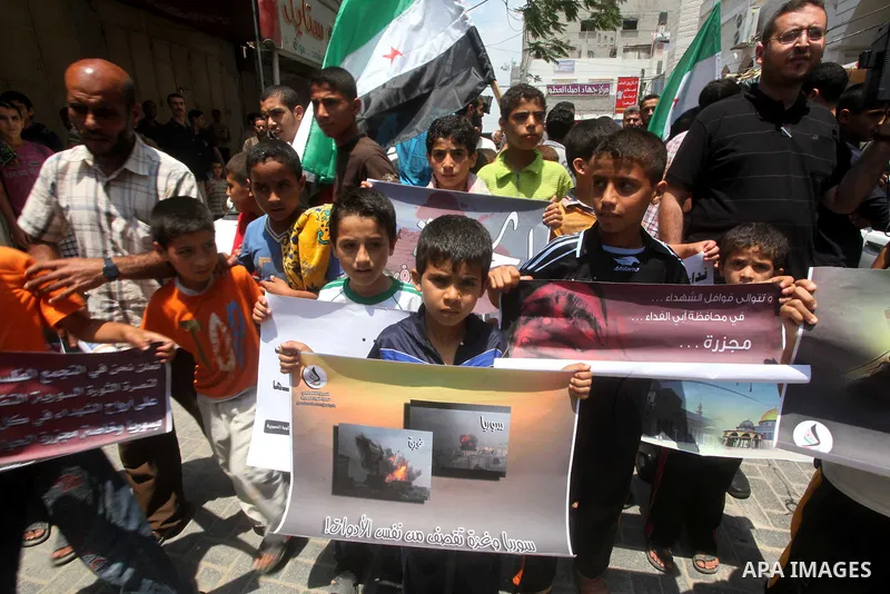 Palestinian children hold a Syrian revolution flag during a protest against Syria's President Bashar al-Assad and in support of Syrian civilians at Nusseirat refugee camp in the central Gaza Strip on June 22, 2012. The F...