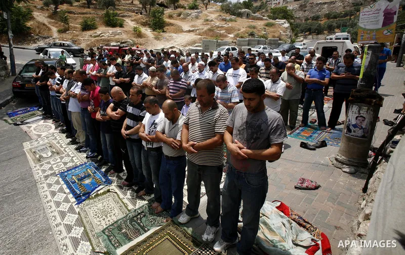 Palestinian Muslim worshippers attend Friday prayers outside a protest tent against the continuing 'Judaization of Jerusalem' by Jewish settlers, in the mostly Arab neighbourhood of Silwan in east Jerusalem on June 22, 2...