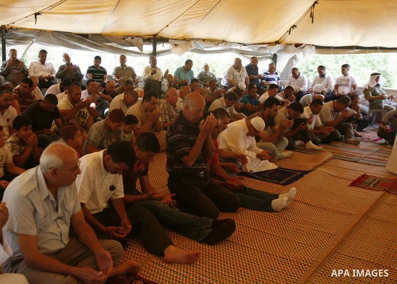 Palestinian Muslim worshippers attend Friday prayers outside a protest tent against the continuing 'Judaization of Jerusalem' by Jewish settlers, in the mostly Arab neighbourhood of Silwan in east Jerusalem on June 22, 2...