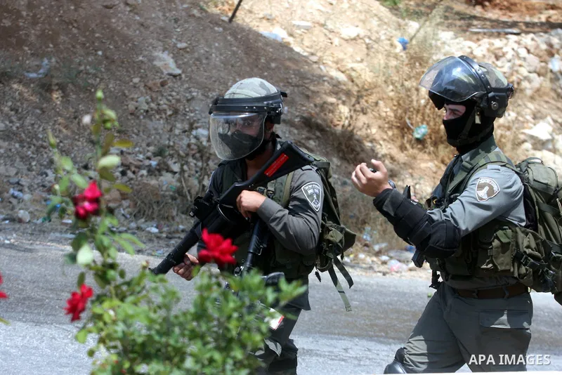 An Israeli soldier fires a tear gas canister during clashes with Palestinian protesters in the West Bank village of Nabi Saleh, near Ramallah, on June 22, 2012, following a demonstration against the confiscation of Pales...