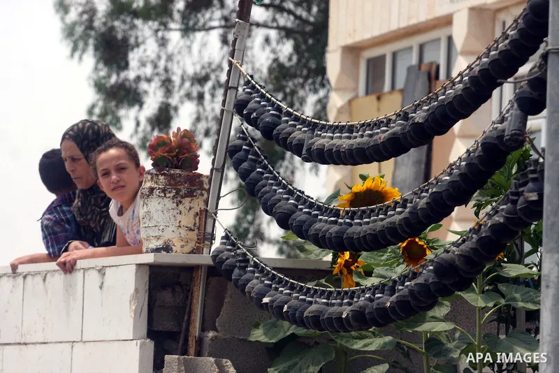 A Palestinian family look at the Israeli soldiers during clashes with Palestinian protesters in the West Bank village of Nabi Saleh, near Ramallah, on June 22, 2012, following a demonstration against the confiscation of...