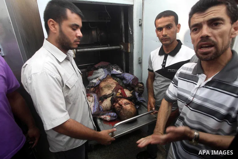 Relatives of Palestinian militant Basil Ahmed look at his body at al-Aqsa hospital in Deir Al Balah, central Gaza strip, following an Israeli airstrike east of Bureij refugee camp Friday, June 22, 2012. An Israeli air st...
