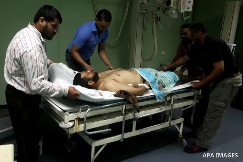 Palestinian medics wheel a wounded man to the treatment room of Al-Aqsa hospital following an Israeli airstrike east of Bureij refugee camp, in Deir Al Balah, central Gaza strip, Friday, June 22, 2012. An Israeli air str...