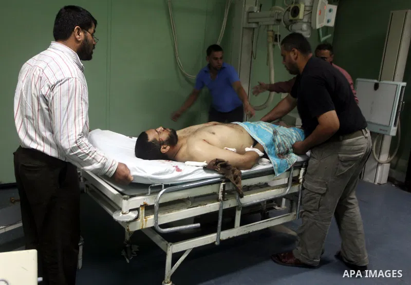 Palestinian medics wheel a wounded man to the treatment room of Al-Aqsa hospital following an Israeli airstrike east of Bureij refugee camp, in Deir Al Balah, central Gaza strip, Friday, June 22, 2012. An Israeli air str...