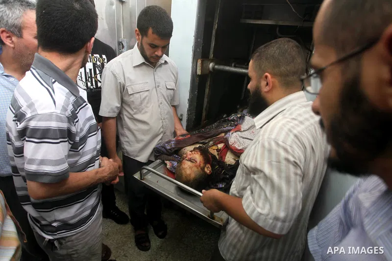 Relatives of Palestinian militant Basil Ahmed look at his body at al-Aqsa hospital in Deir Al Balah, central Gaza strip, following an Israeli airstrike east of Bureij refugee camp Friday, June 22, 2012. An Israeli air st...