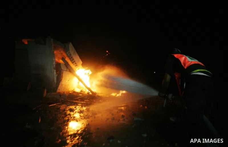 Hamas Police and firemen look at the damages and try to put out a fire at the al-Saraya Security complex following an Israeli air strike on Gaza on June 23, 2012. Israel launched more air strikes against on the Gaza Stri...