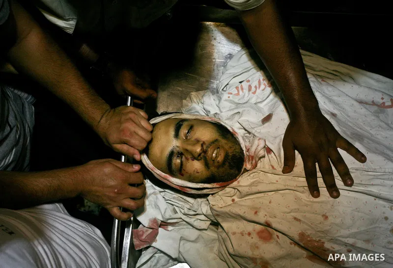 Palestinians stand next to the body of Hamas' security forces at a hospital in Al Shefa after Israeli air raids hit Hamas security sites in Gaza City June 23, 2012. Israel launched air raids early on Saturday against thr...