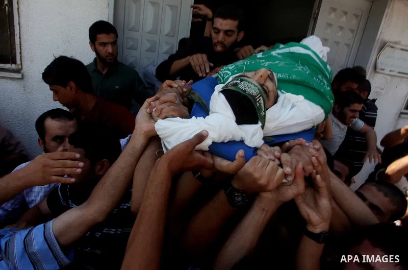 Palestinians carry the body of Hamas militant Hamam Abu Qadus during his funeral in Gaza City June 23, 2012. Israel launched air raids early on Saturday against three Hamas security targets in the Gaza Strip, wounding at...