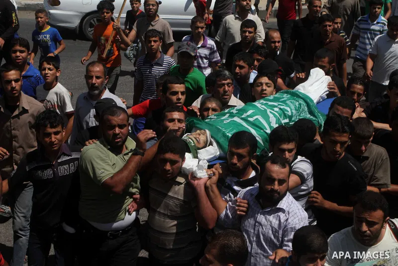 Palestinians carry the body of Hamas militant Hamam Abu Qadus during his funeral in Gaza City June 23, 2012. Israel launched air raids early on Saturday against three Hamas security targets in the Gaza Strip, wounding at...