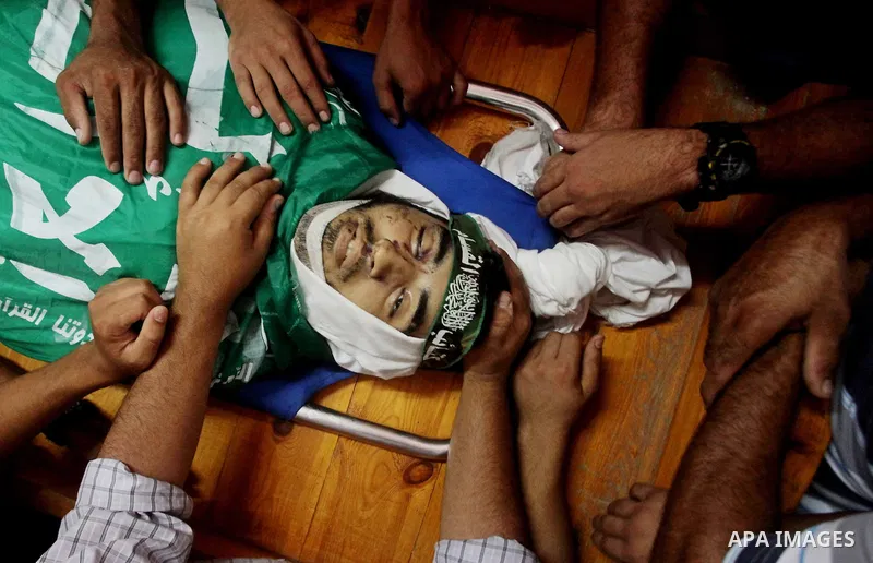 Palestinians carry the body of Hamas militant Hamam Abu Qadus during his funeral in Gaza City June 23, 2012. Israel launched air raids early on Saturday against three Hamas security targets in the Gaza Strip, wounding at...