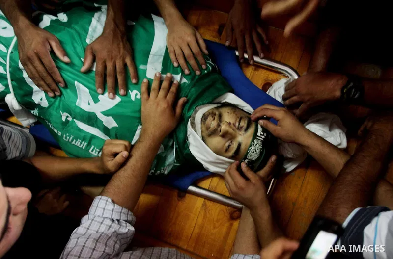 Palestinians carry the body of Hamas militant Hamam Abu Qadus during his funeral in Gaza City June 23, 2012. Israel launched air raids early on Saturday against three Hamas security targets in the Gaza Strip, wounding at...